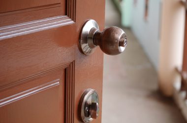 serrure tubulaire ronde à l'américaine sur porte en bois. porte à moitié ouverte.