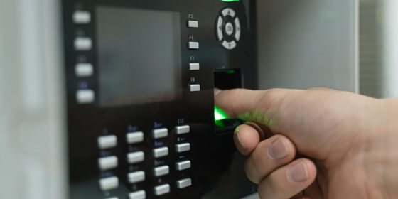 Une main utilisant un scanner d'empreintes digitales avec le pouce pour l'identification ou pour entrer dans l'usine. Serrurerie industrielle