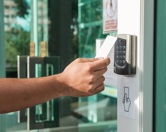 Main utilisant la numérisation de la carte-clé de sécurité pour ouvrir la porte pour entrer. Serrurier moderne, système d'ouverture de porte avec carte